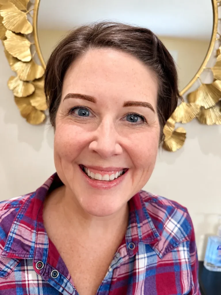 Smiling client showing warm reddish-brown Nano Brows at Vivi Brows & Head Spa in London, Ontario